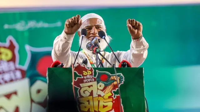 চট্টগ্রামে লং মার্চের সমাবেশে জামায়াতে ইসলামীর আমির শফিকুর রহমান। তিনি দুই হাত মুষ্টিবদ্ধ করে ওপরের দিকে তুলে আছেন
